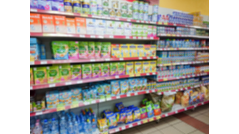 Blurred abstract image. Goods on the shelf of a grocery store. Different baby food