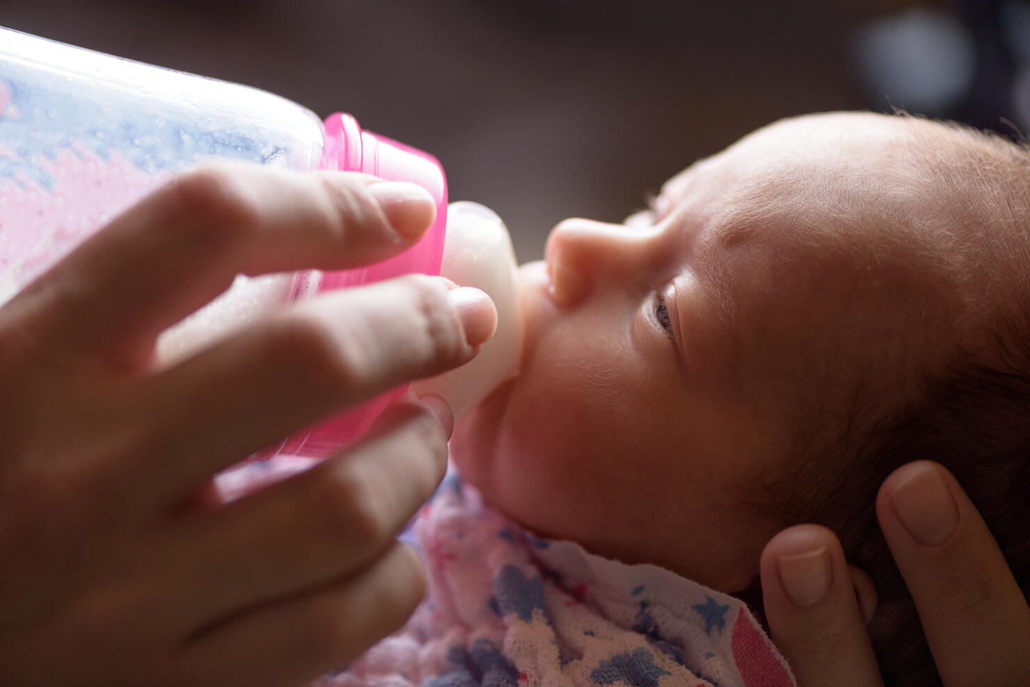 Mother feeds the newborn with bottle milk