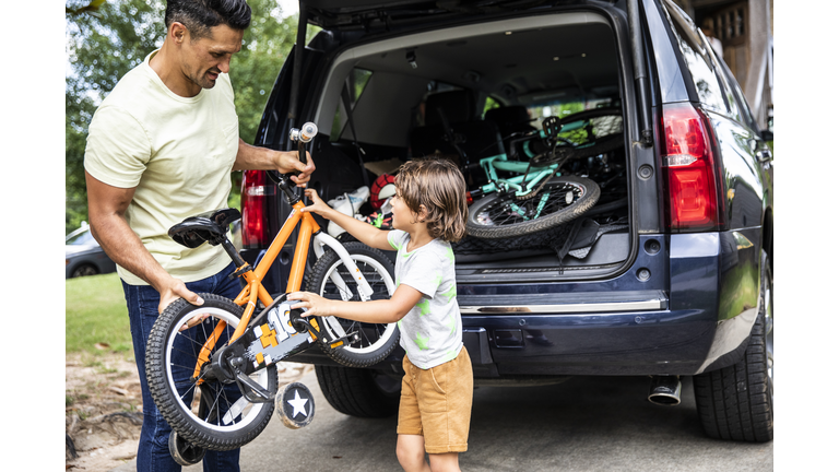 Father and son loading bicycles into car