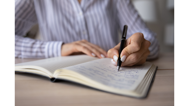 Close up of woman write make notes in notebook