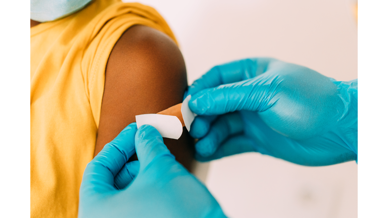 Doctor putting a bandage after Covid-19 vaccination.