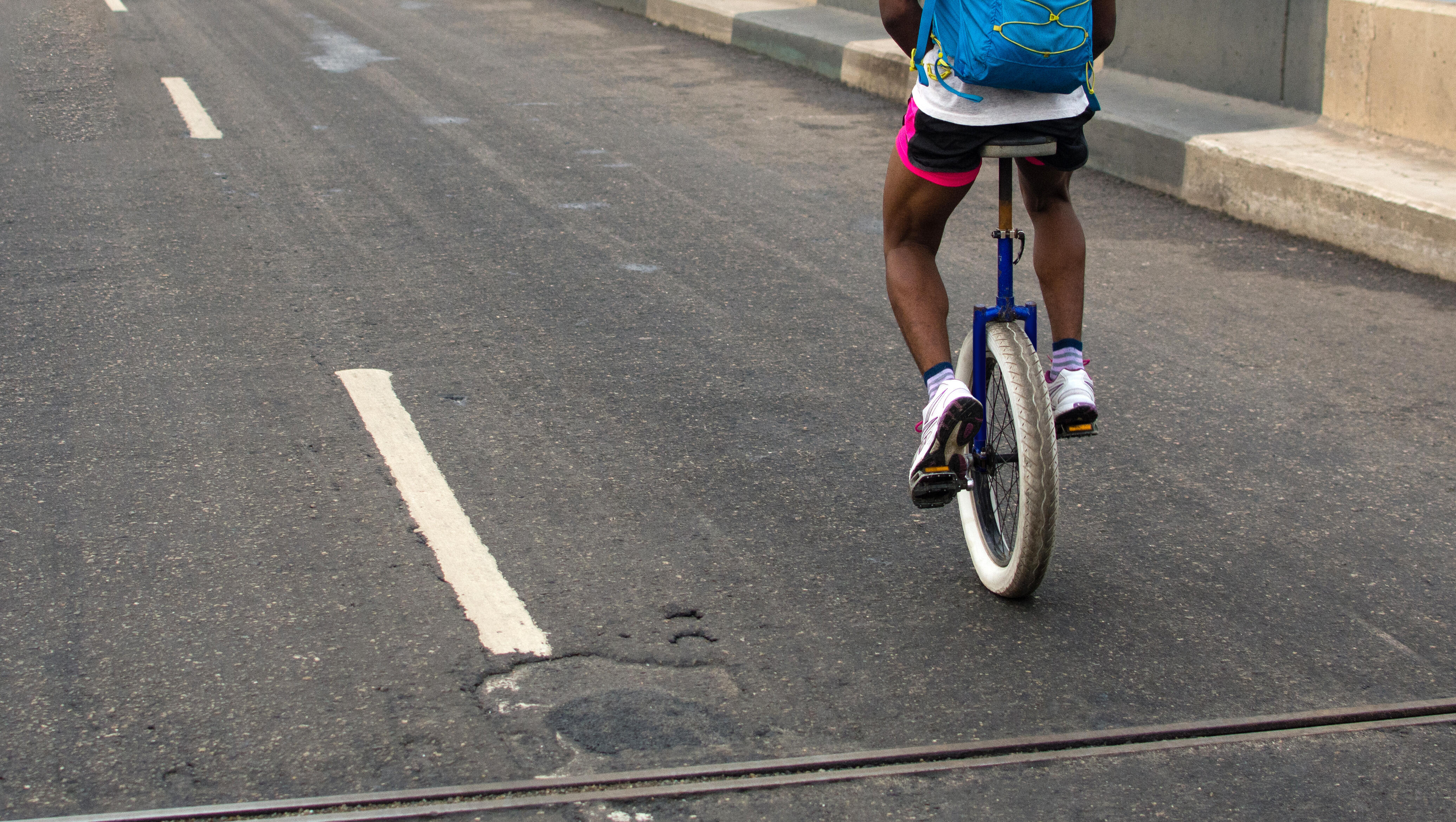 Watch Some Dude Ride a Unicycle While Carrying 7 Bowling Balls
