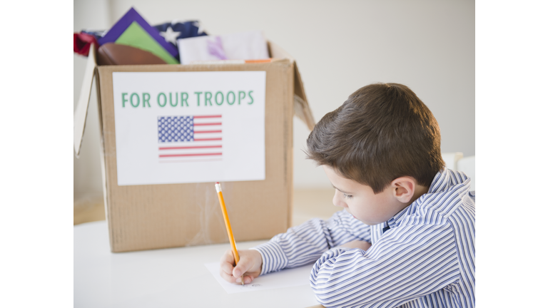 Young boy preparing care package for US Troops