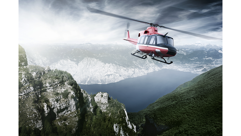 Helicopter flying over mountains and a lake