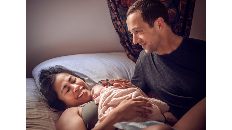 Home Birth - Smiling Parents With Newborn