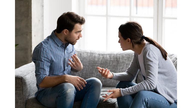 Stressed young married family couple arguing, blaming each other.