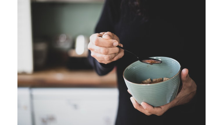 A man eating / holding a bowl full of shredded wheat