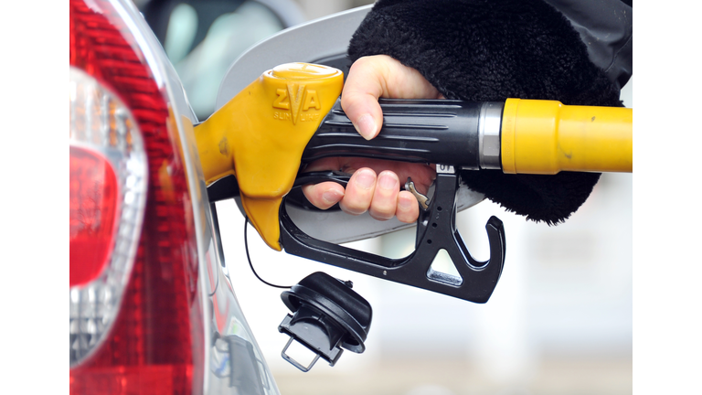 A person fills up her car at an oil stat