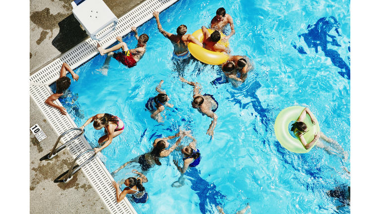 Group of friends playing together in outdoor pool