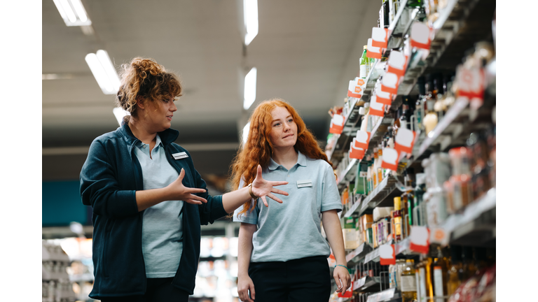 Supermarket manager giving training to a trainee employee