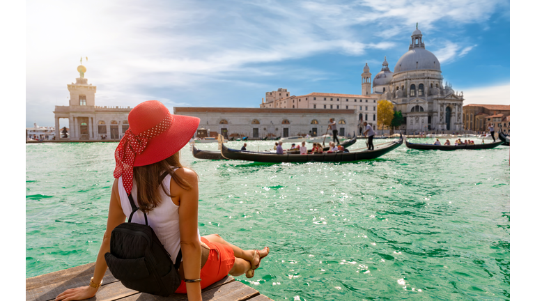 Female tourist looking the Basilica di Santa Maria della Salute and Canale Grande in Venice, Italy