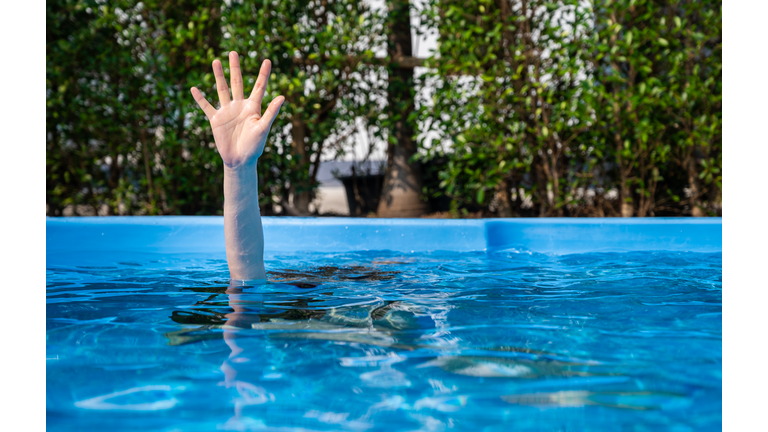 Hand of person drowing in swimming pool.
