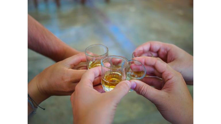 Five human hands toasting with pisco