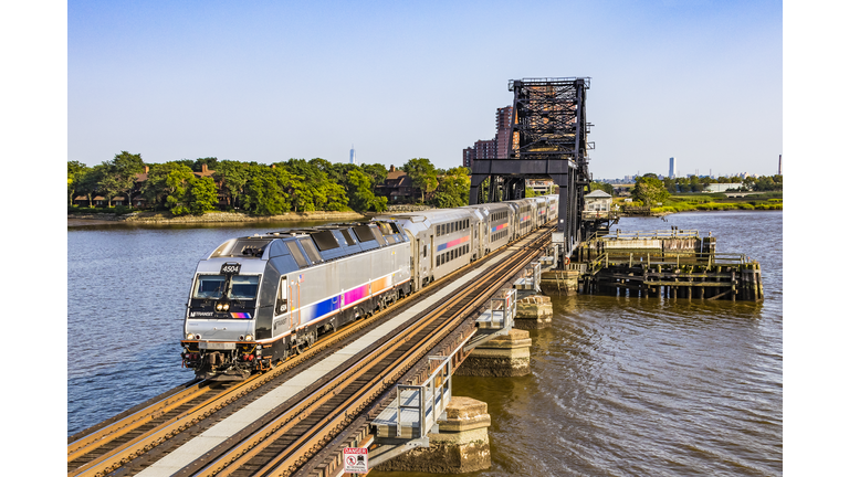 Corporate NJ Transit Bombardier commuter train crossing Hackensack River bridge