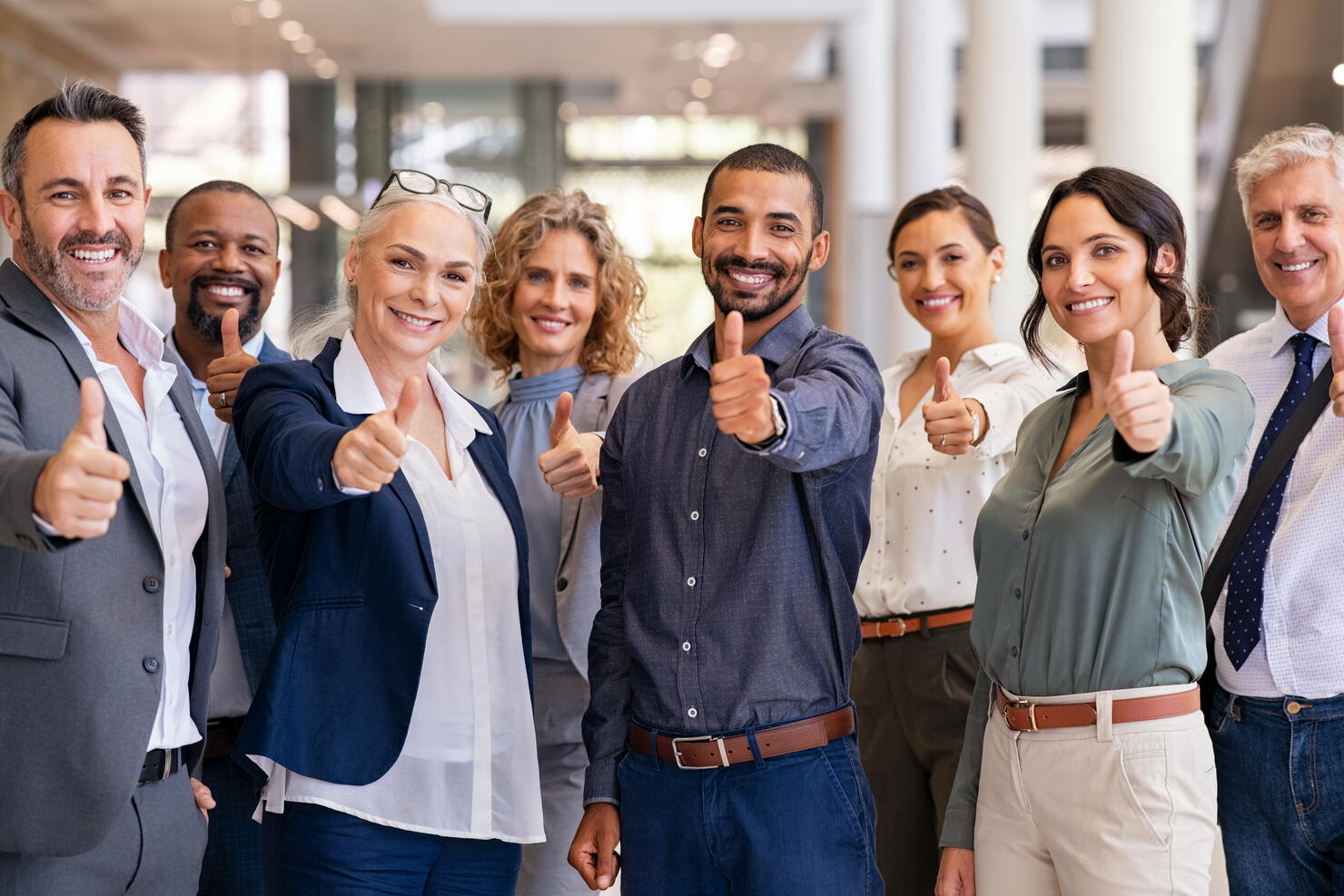 Group of successful business people showing thumbs up