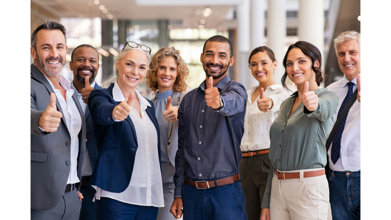 Group of successful business people showing thumbs up