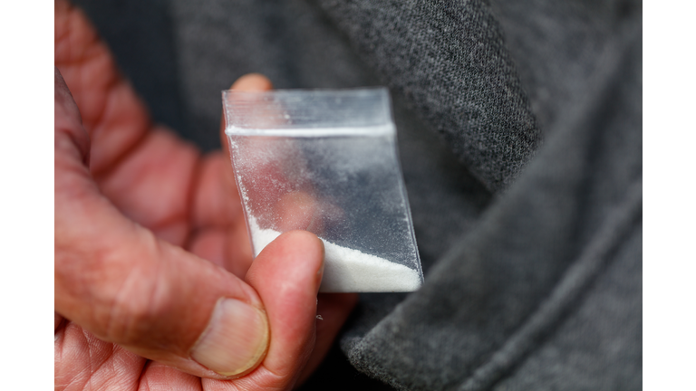 fentanyl heroin opiate in plastic bag in hand close-up in pocket