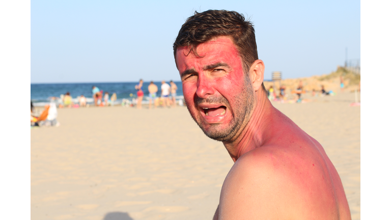 Childish looking adult crying at the beach