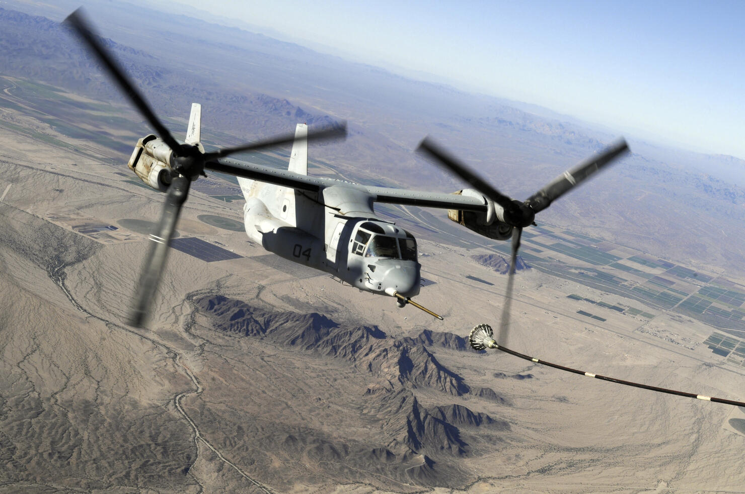 A Marine Corps MV-22 Osprey prepares to refuel midflight.