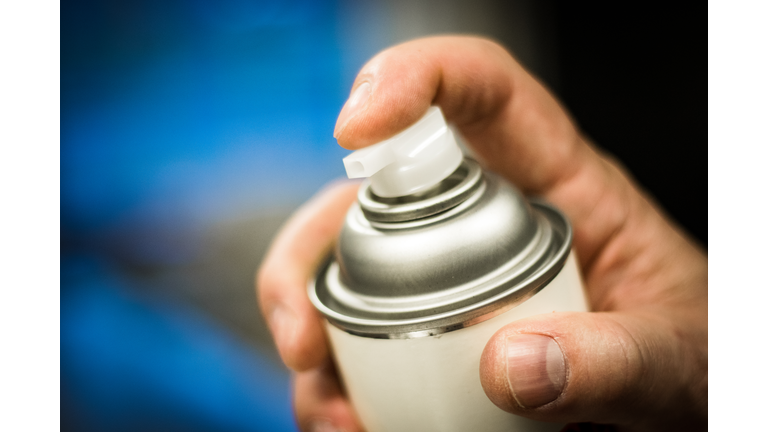 Aerosol spray can in hand ready to dispense.