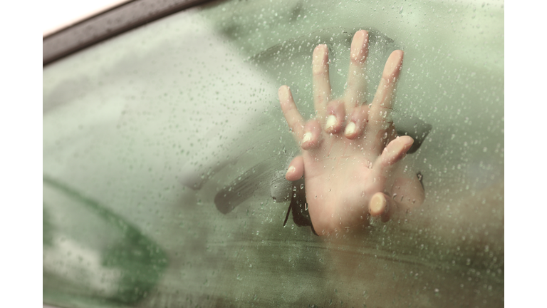 Couple holding hands having sex inside a car