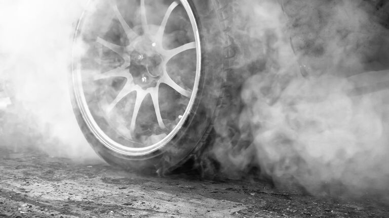 Drag racing car burns rubber off its tires in preparation for the race