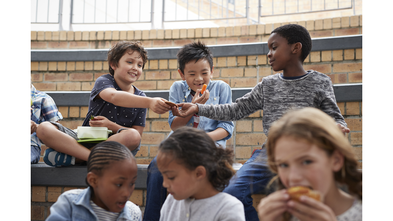 School children having lunch together outside the building