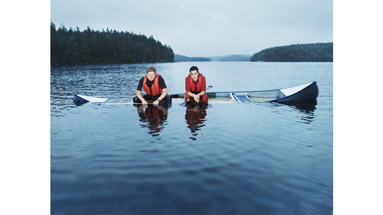 Man and woman sitting in sinking canoe