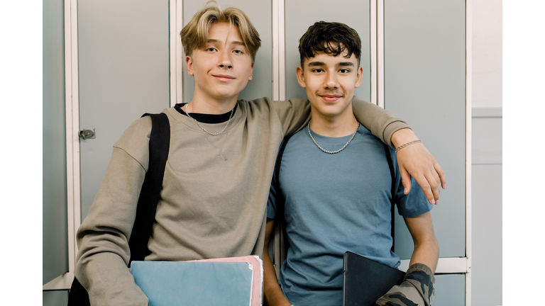 Teenage male friends standing in front of locker