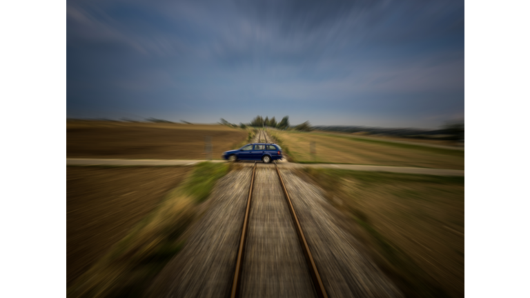 Train perspective of a car passing a railroad crossing with medium motion blur
