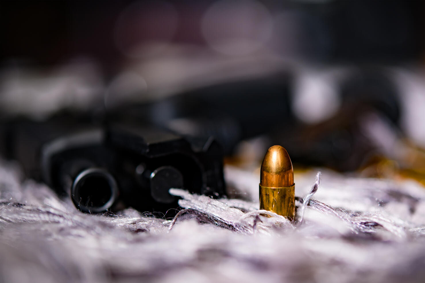 Photo of a gun and bullets on floor.