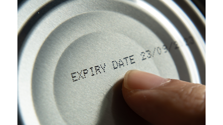 Finger pointing at the expiry date on canned food