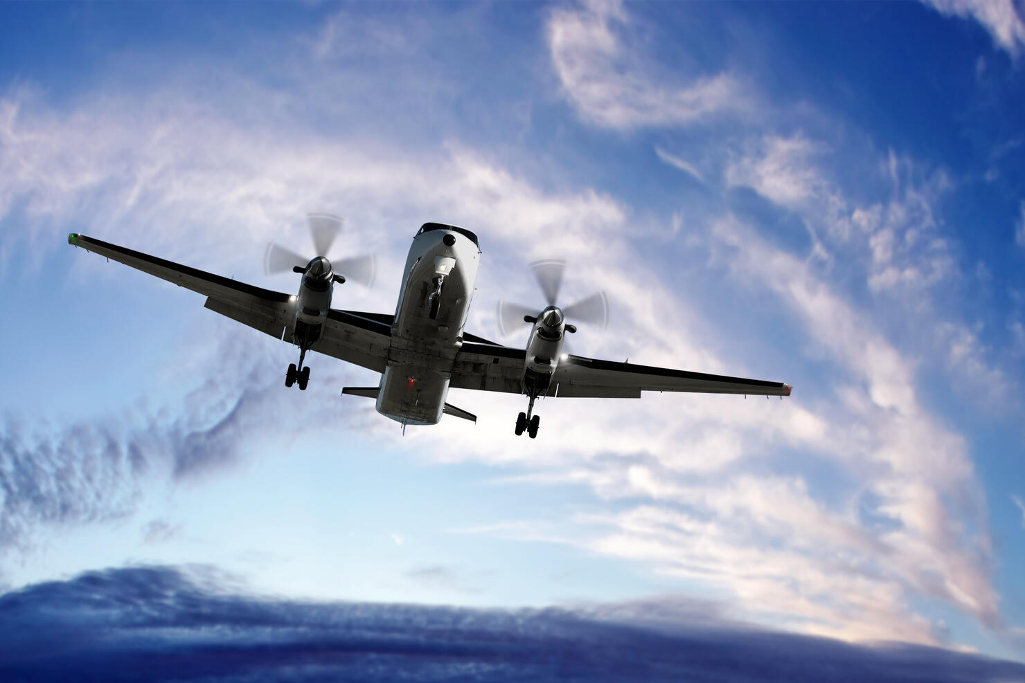 XL propeller airplane landing at sunset