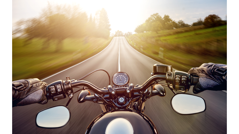 POV shot of young man riding on a motorcycle. Hands of motorcyclist on a street