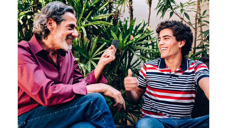 Father giving condom to his son