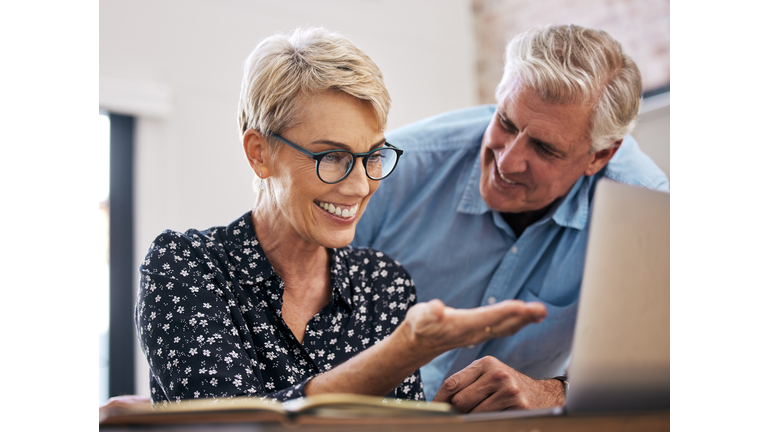 Shot of a mature couple using a laptop at home