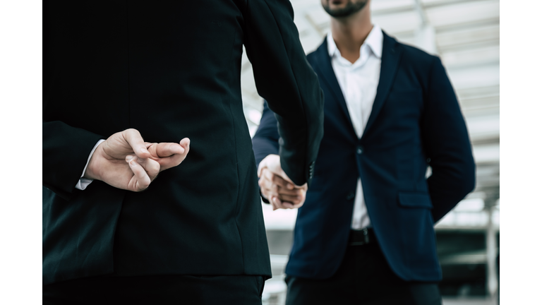 Businessman or politician cross finger, hiding behind his back during he get handshake to another person, businessman. Businessman pretend to be good person, he is liar. White collar worker is fraud