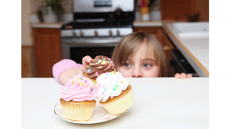 Little girl sneaking cupcake