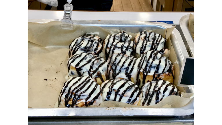 Cinnamon Buns in Glaze for Sale at Showcase of Dessert Shop / Cinnabon in Tray.