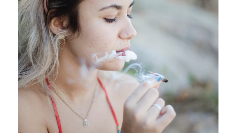 Close-Up Of Woman Smoking Marijuana Joint