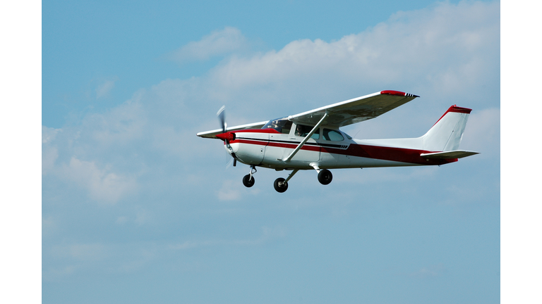 private airplane Cessna 172 in blue sky with white clouds