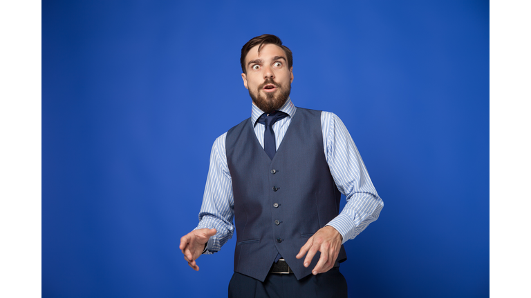 Man looking terrified on blue background