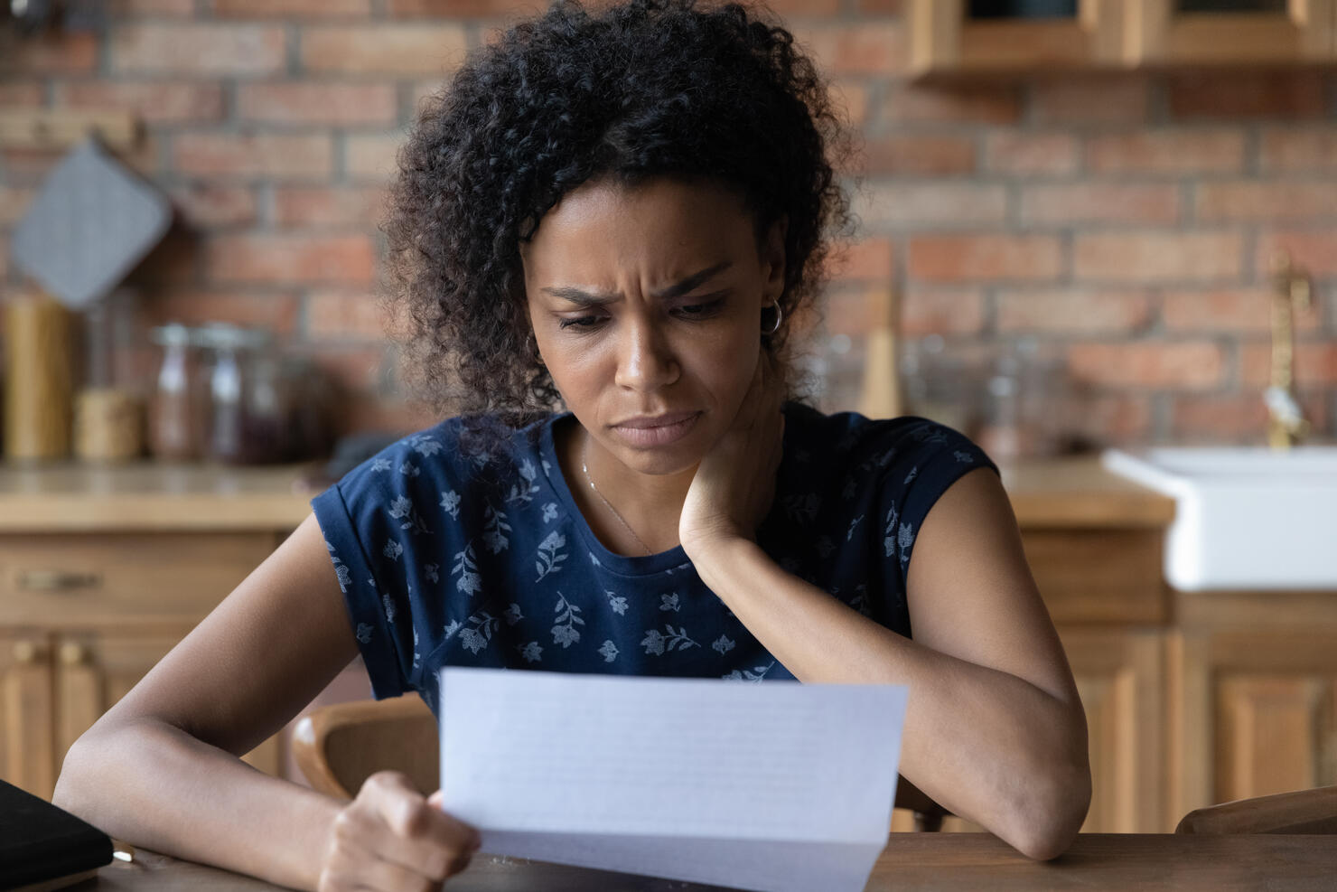 Close up unhappy African American woman reading letter, bad news