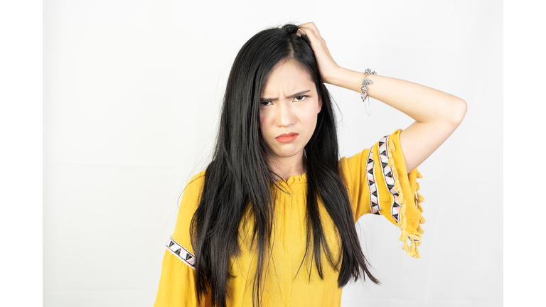 Young woman possed a confusing and thinking face on white background.