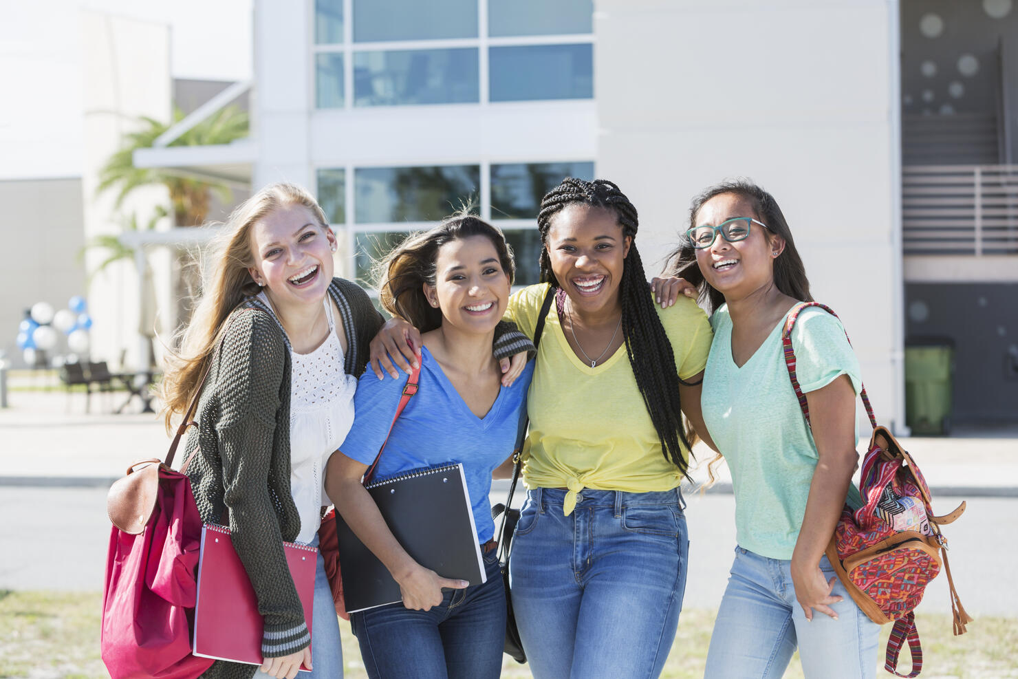 Four multi-ethnic teenage students on campus