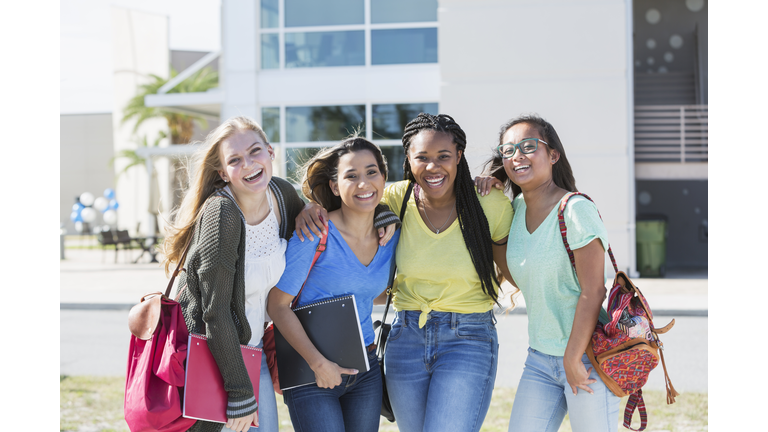 Four multi-ethnic teenage students on campus