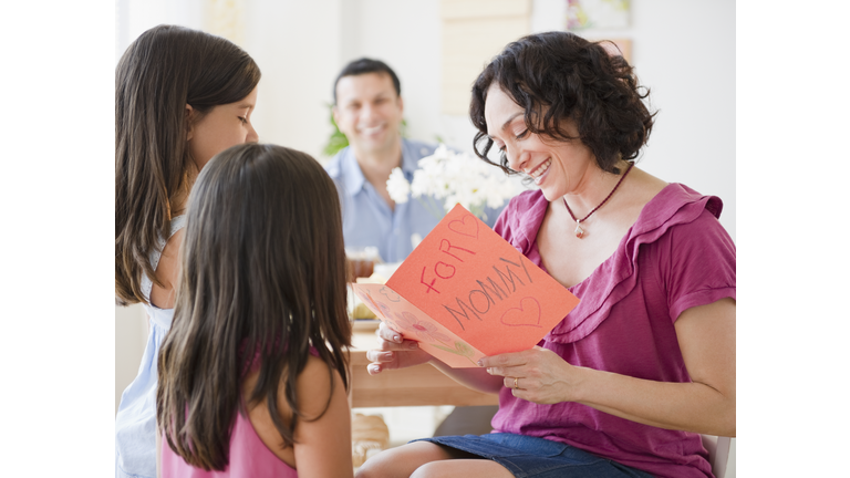 Daughters giving mother Mother's Day card
