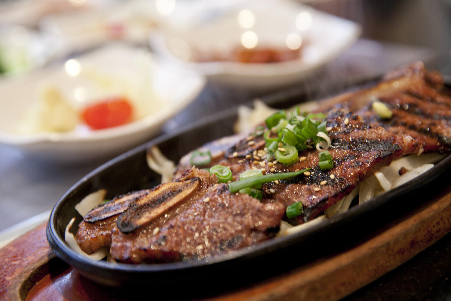A close-up of Korean BBQ short ribs in a black dish