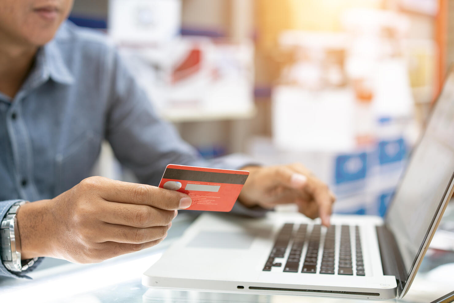 Hands holding credit card, typing on the keyboard of laptop, onine shopping detail close up