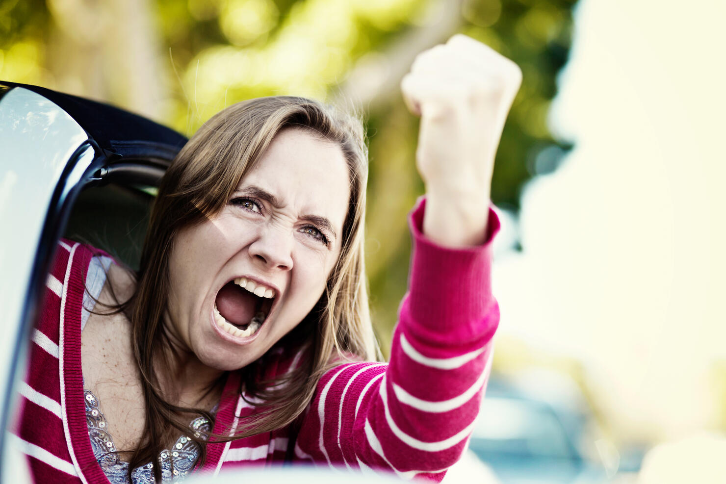 Women drivers get road rage too! Furious female shaking fist